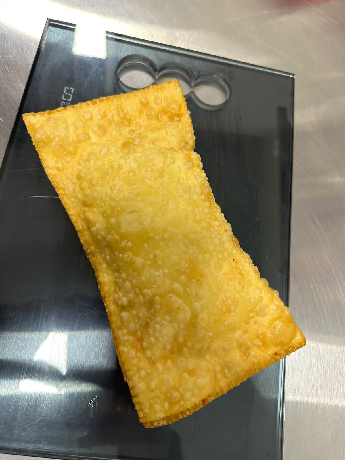 Pastel artesanal dourado, massa fininha cheia de bolhas